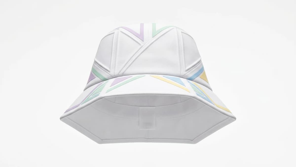 A white bucket hat with pastel chevrons, packshot on the studio ground