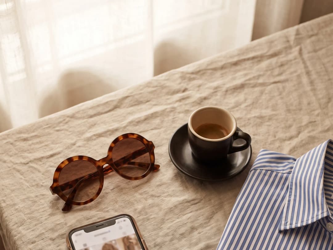 A phone showing a feed of fashion photos on a linen table