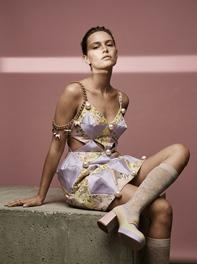 Seated female model in a floral patchwork top with pearl buttons