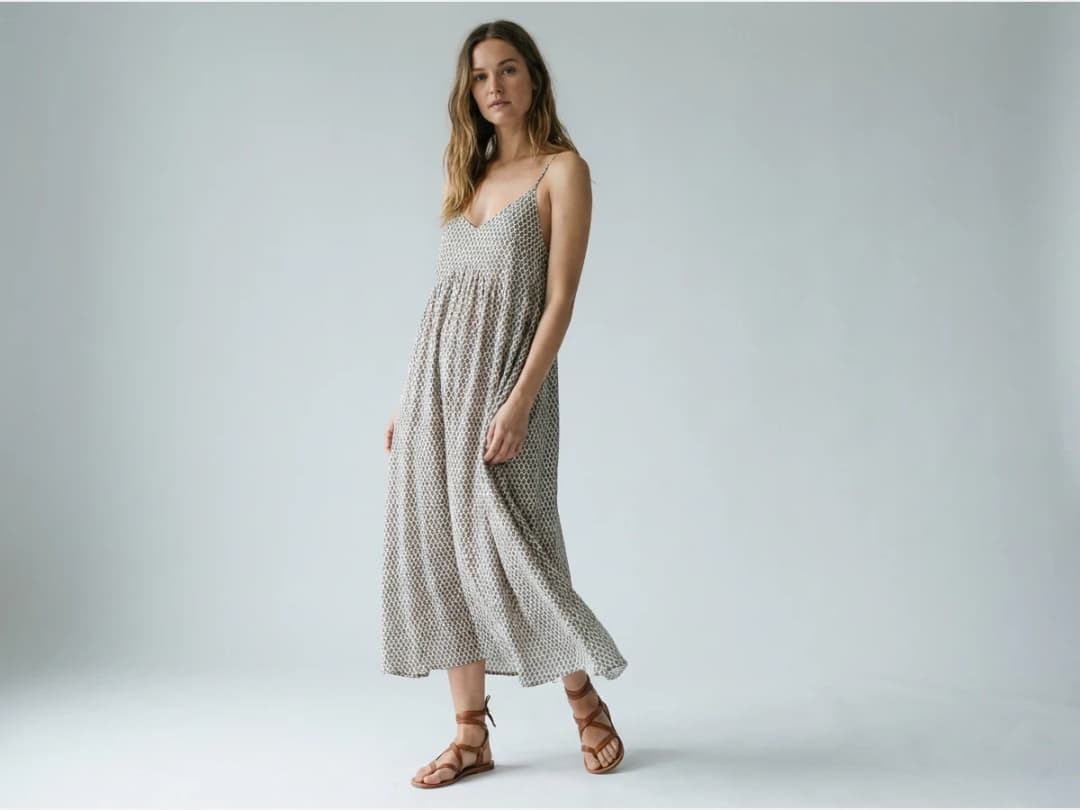 a model photographed to show footwear, sandals with a summer dress